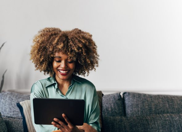 A Happy Beautiful Businesswoman Working From Home On Her Tablet